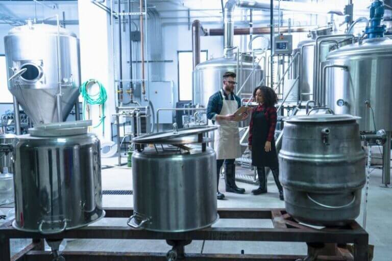 colleagues-in-brewery-standing-looking-at-clipboar-2023-11-27-05-36-27-utc